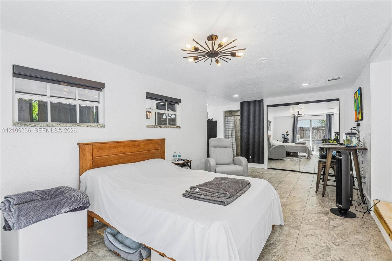 Interior room featuring large-format tile flooring, multi-arm sputnik-style ceiling light fixture, recessed lighting, and mirrored sliding closet doors