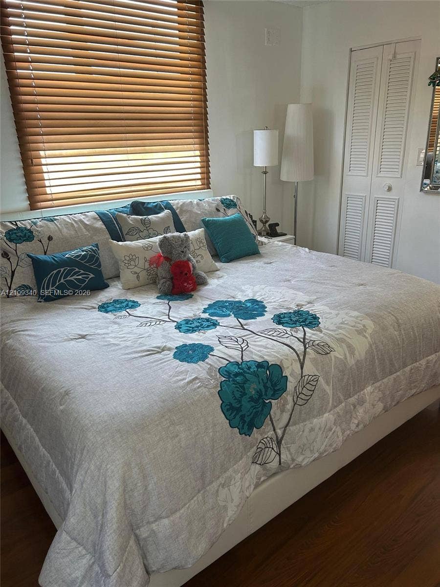 Wood-finish flooring, horizontal window blinds, and louvered closet doors