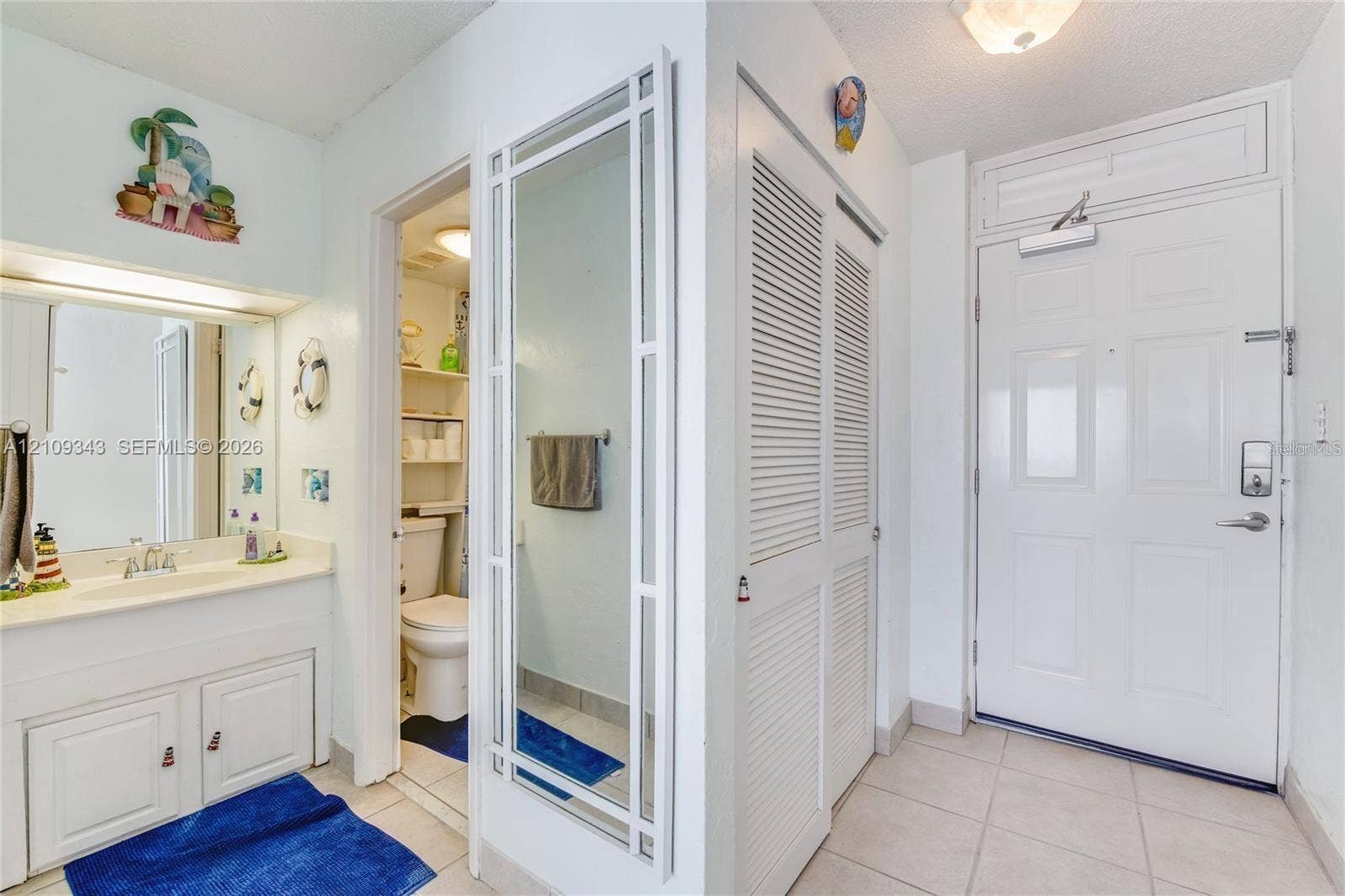 Entryway featuring ceramic tile flooring, a louvered-door closet, and a white entry door with a heavy-duty hydraulic closer