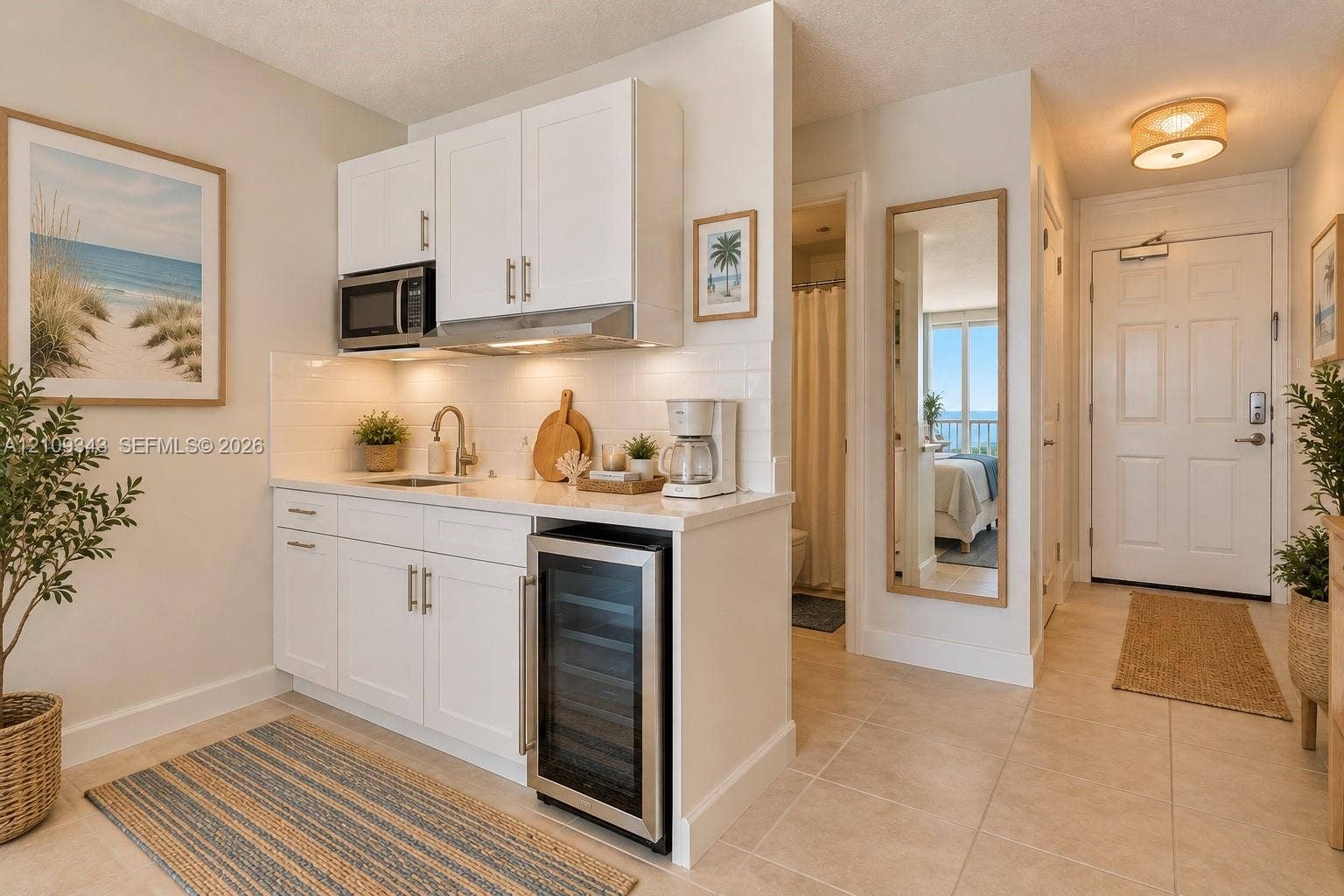 Kitchenette featuring white cabinetry, integrated stainless steel under-counter refrigerator, built-in microwave, stone-surface countertop, and subway tile backsplash