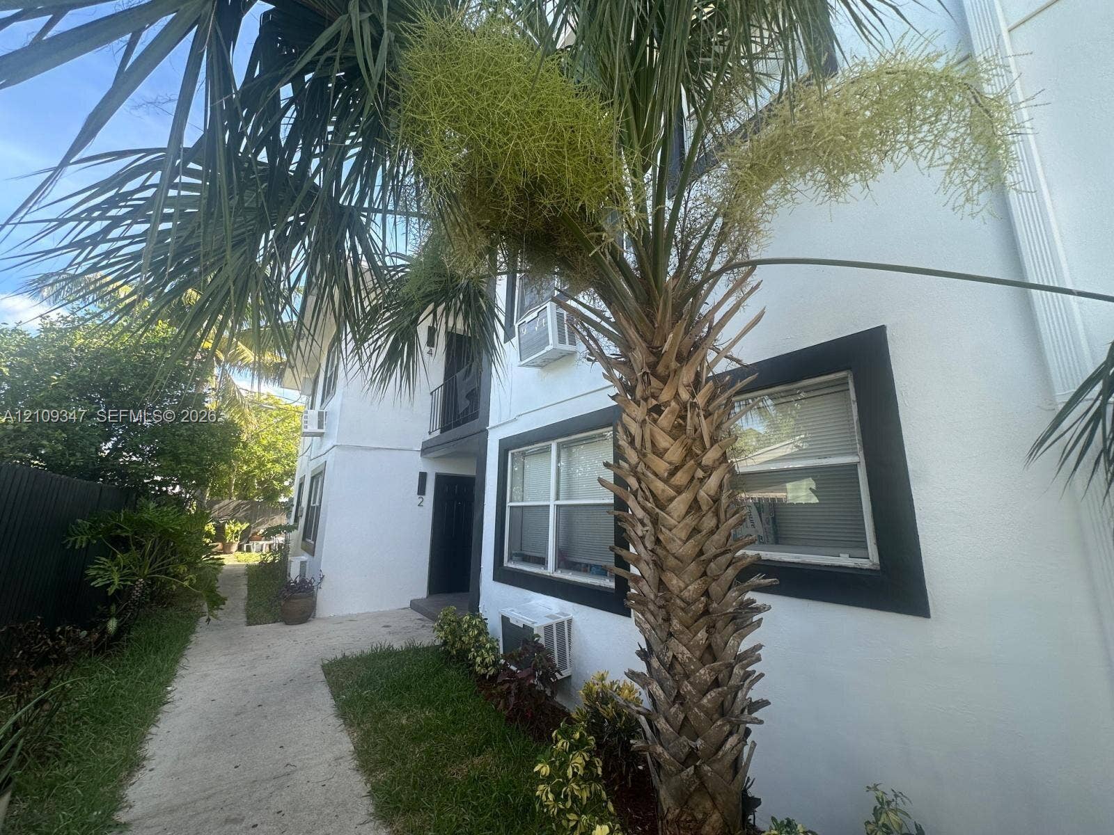3128 SW 12th Place, #1-4, Fort Lauderdale, Fort Lauderdale, FL 33312 Multi-story exterior featuring white stucco finish, dark-trimmed window frames, and mature palm landscaping