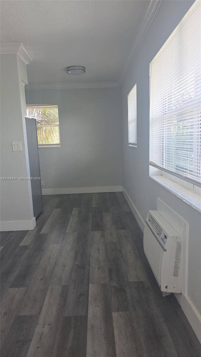 3128 SW 12th Place, #1-4, Fort Lauderdale, Fort Lauderdale, FL 33312 Wood-finish flooring, neutral wall tones, crown molding, windows with integrated blinds, and wall-mounted climate control unit