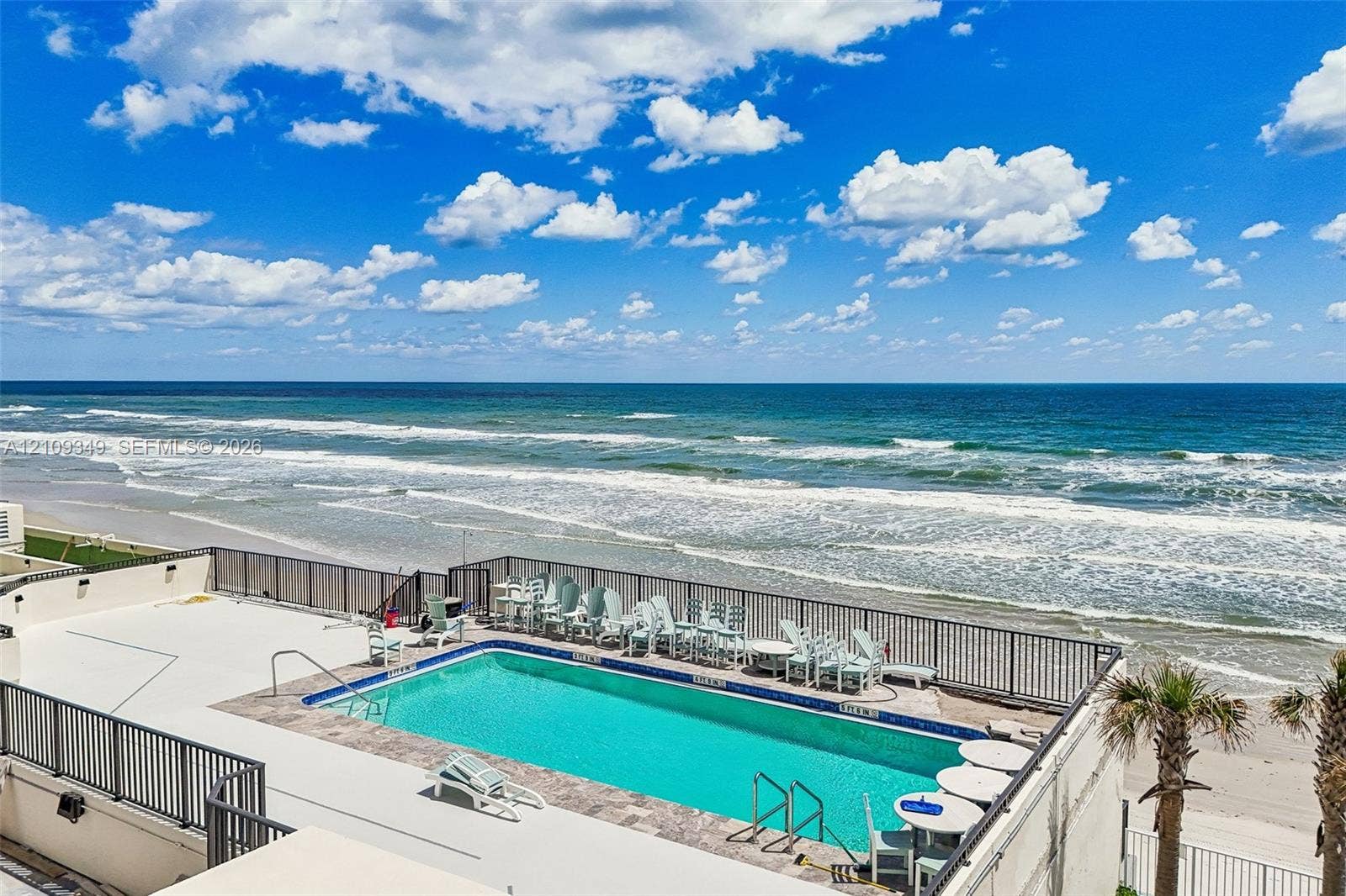 3115 S Atlantic Avenue, #G030, Daytona Beach, FL 32118 Elevated swimming pool featuring a tile surround, metal perimeter railing, and oceanfront placement