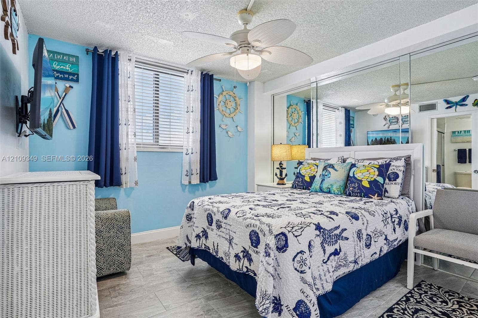 3115 S Atlantic Avenue, #G030, Daytona Beach, FL 32118 Bedroom featuring tile flooring, ceiling fan with integrated lighting, and wall-to-wall mirrored closet doors