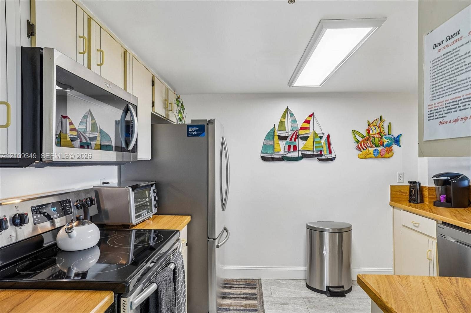 3115 S Atlantic Avenue, #G030, Daytona Beach, FL 32118 Kitchen featuring stainless steel appliances, butcher block countertops, white cabinetry, and flush-mount LED lighting