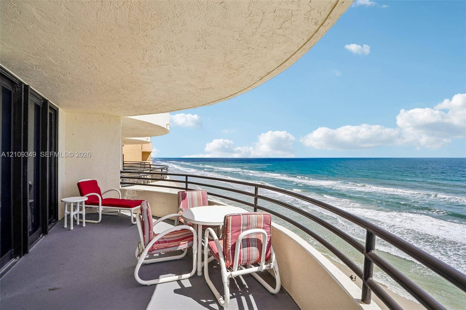 3115 S Atlantic Avenue, #G030, Daytona Beach, FL 32118 Curved covered balcony with a concrete floor, metal railings, and direct ocean exposure
