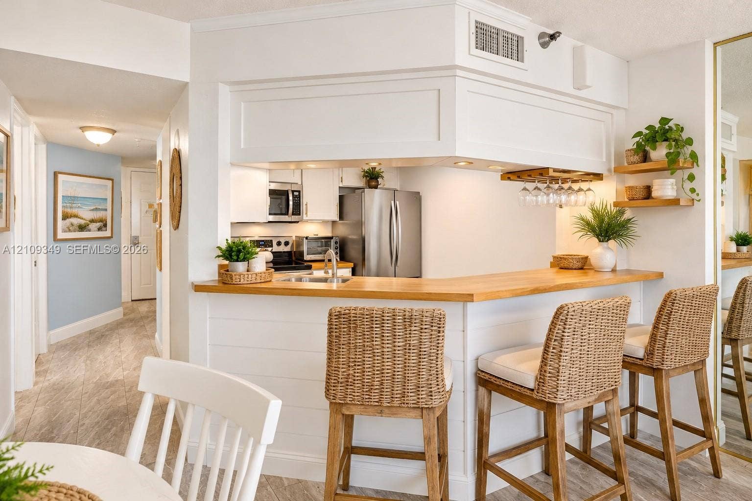 3115 S Atlantic Avenue, #G030, Daytona Beach, FL 32118 Kitchen featuring white cabinetry, wood-finish breakfast bar counter, recessed lighting, and built-in stemware storage