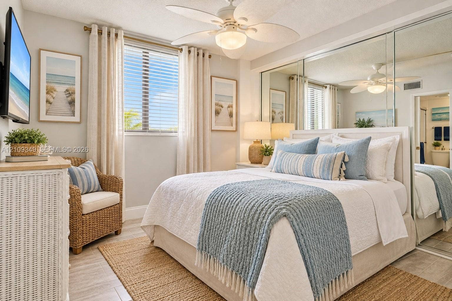 3115 S Atlantic Avenue, #G030, Daytona Beach, FL 32118 Bedroom featuring tile flooring, ceiling fan with integrated lighting, window with slatted blinds, and floor-to-ceiling mirrored wardrobe doors