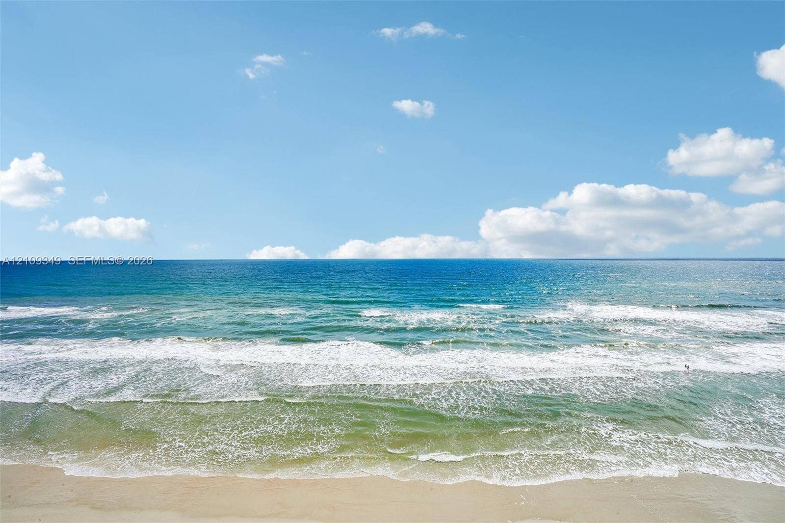 3115 S Atlantic Avenue, #G030, Daytona Beach, FL 32118 Sandy beach shoreline meeting the ocean with rolling surf and a clear sky horizon