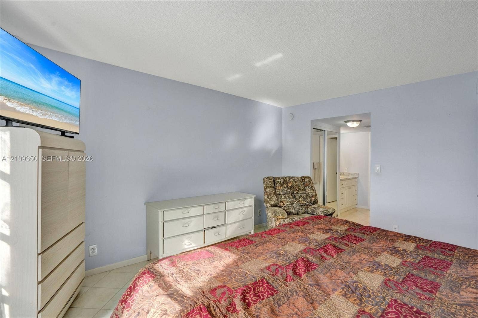 10777 W Sample Road, #616, Coral Springs, FL 33065 Neutral wall finishes, tile flooring, and a recessed doorway providing a glimpse into a secondary room with built-in cabinetry
