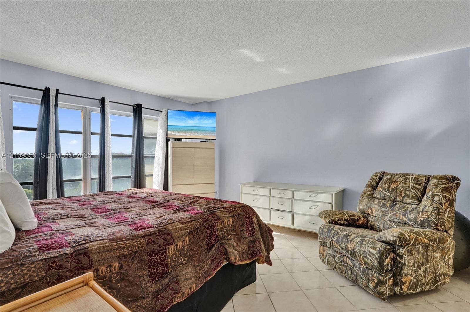 10777 W Sample Road, #616, Coral Springs, FL 33065 Neutral-toned interior space featuring light-colored tile flooring and large multi-pane windows