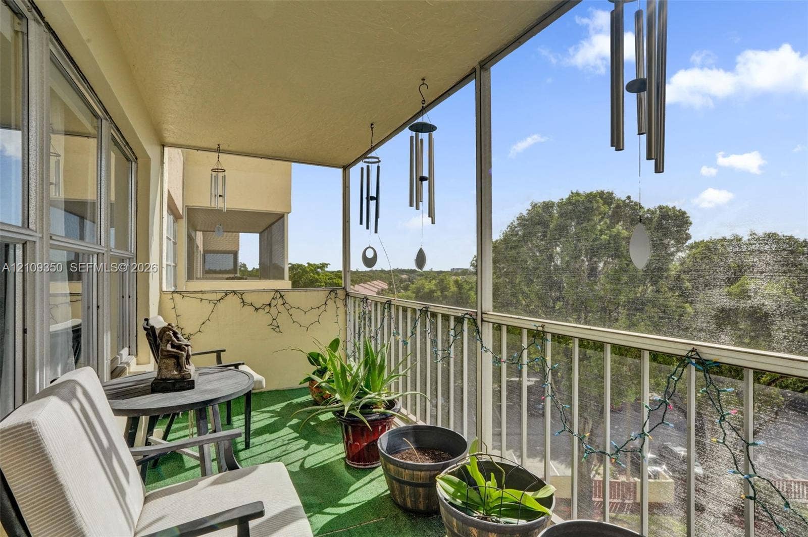 10777 W Sample Road, #616, Coral Springs, FL 33065 Screened-in balcony featuring metal railing, overhead lighting, and solid wall construction