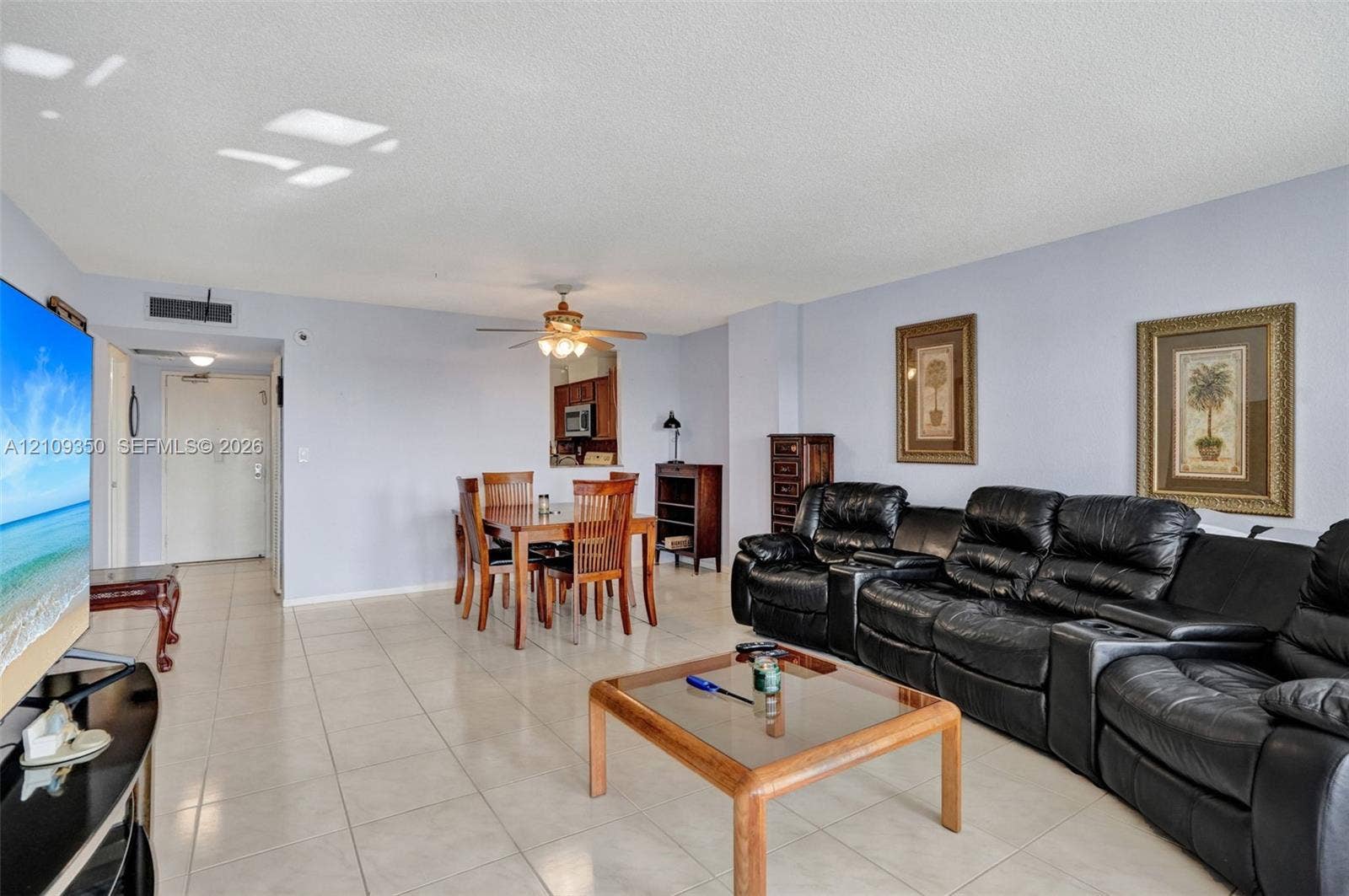 10777 W Sample Road, #616, Coral Springs, FL 33065 Open-concept main living area featuring light-toned tile flooring, neutral wall paint, and a ceiling-mounted fan with integrated lighting