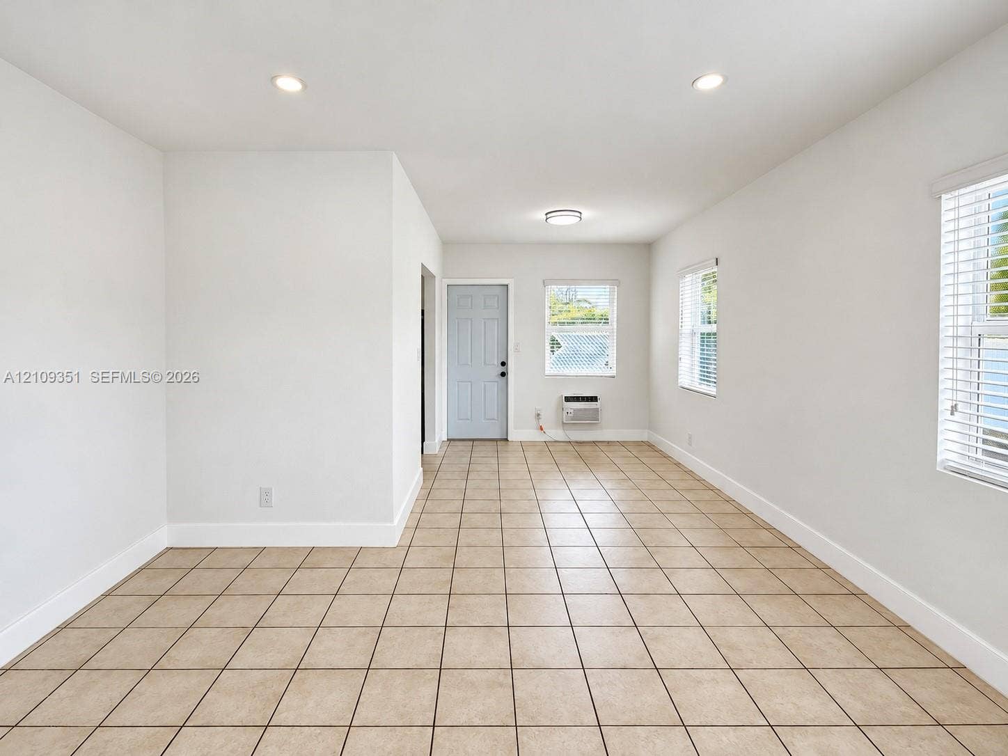 Ceramic tile flooring, recessed lighting, multi-pane windows with horizontal blinds, and a neutral color palette