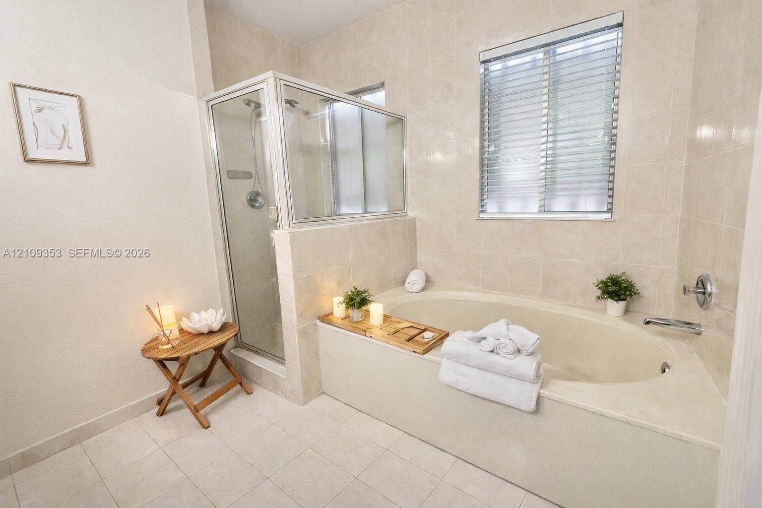 Tiled shower enclosure with a glass door, oval soaking tub, ceramic tile flooring, and wall-mounted plumbing fixtures