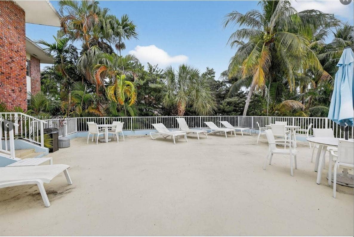 2426 SE 17th Causeway, #103A, Fort Lauderdale, FL 33316 Expansive concrete deck featuring metal perimeter railings and mature palm trees