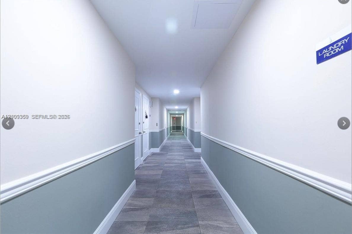 2426 SE 17th Causeway, #103A, Fort Lauderdale, FL 33316 Hallway featuring grey tile flooring, two-tone wall paint, white chair rail molding, and recessed ceiling lighting