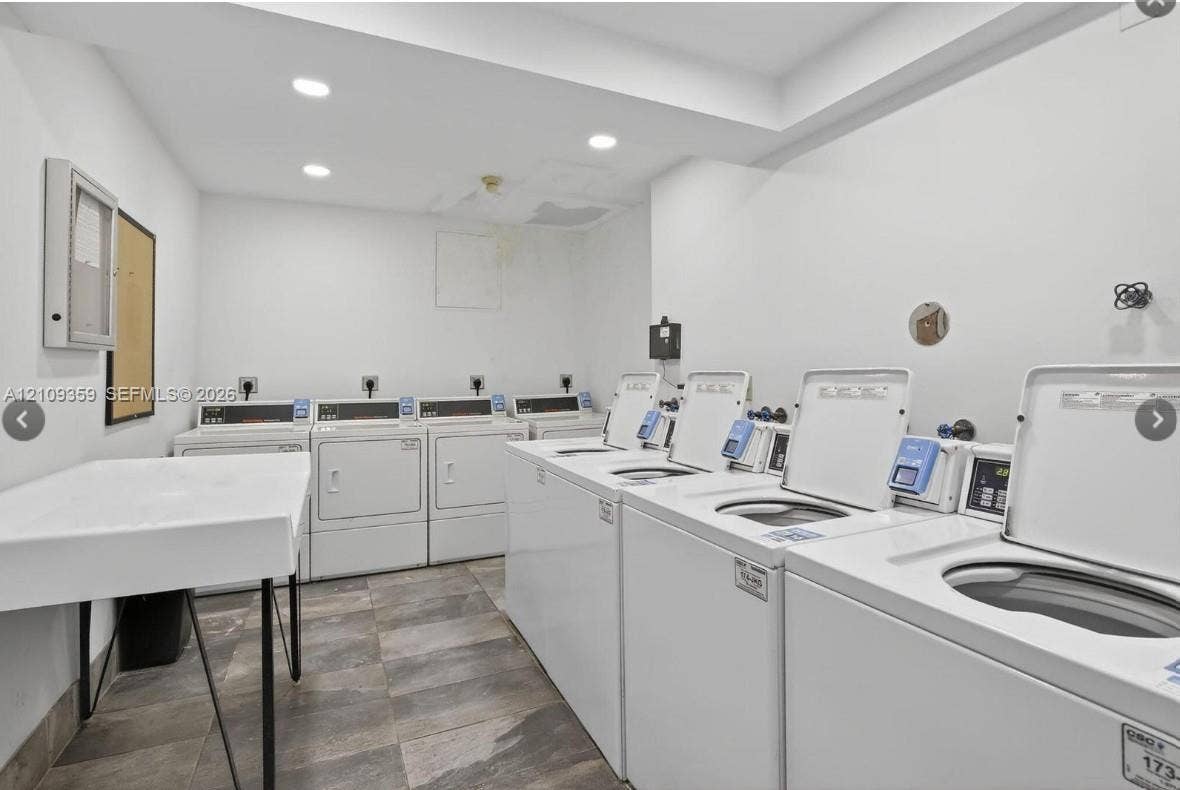 2426 SE 17th Causeway, #103A, Fort Lauderdale, FL 33316 Laundry facility featuring multiple commercial-grade top-load washers and dryers, tile flooring, recessed lighting, and a built-in utility sink