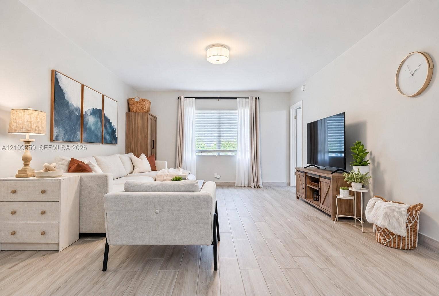 2426 SE 17th Causeway, #103A, Fort Lauderdale, FL 33316 Neutral interior space featuring wood-finish flooring, a single-window configuration with horizontal blinds, and a flush-mount circular ceiling light fixture