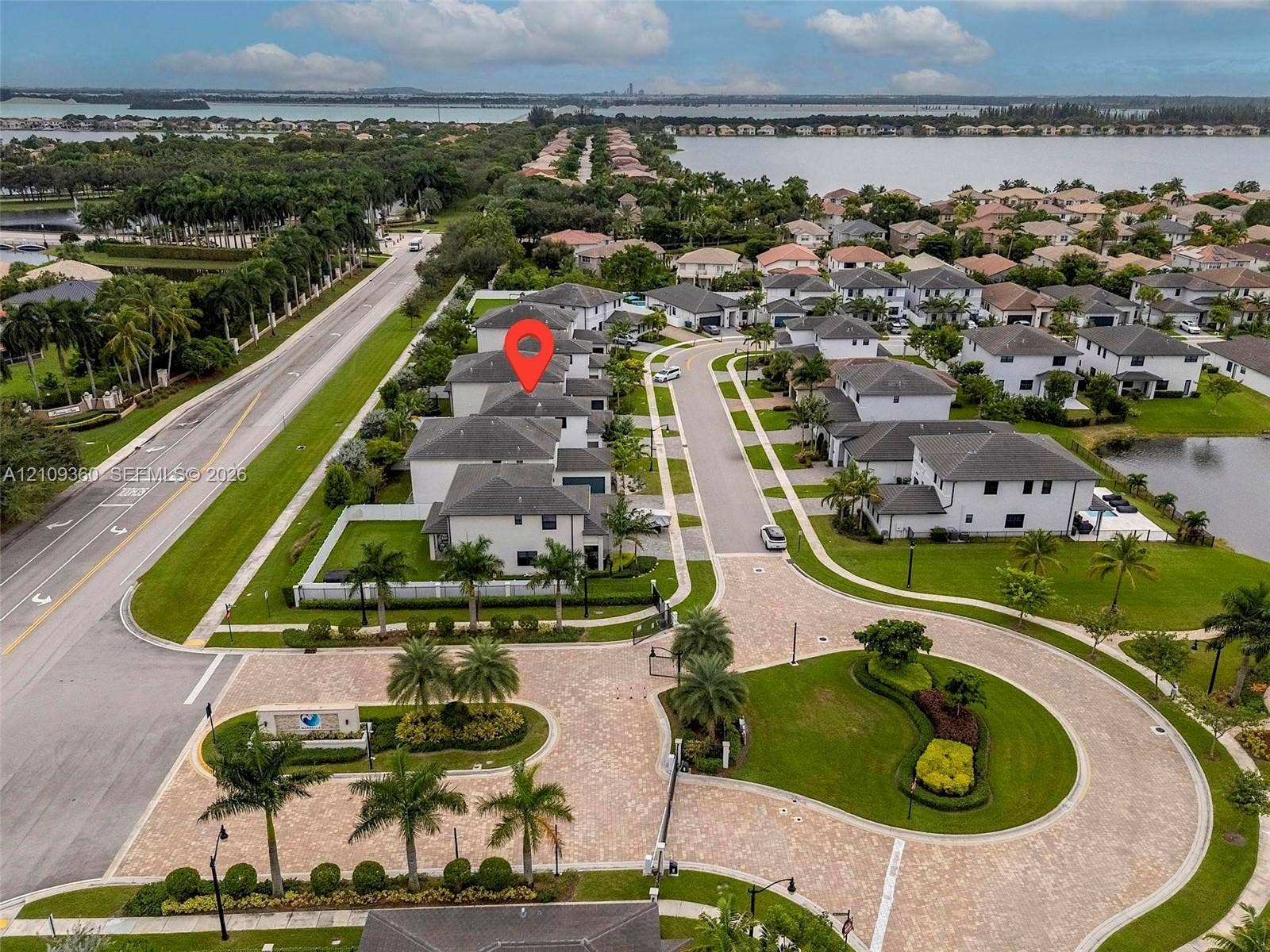 4535 SW 173rd Avenue, Miramar, FL 33029 Aerial perspective of a multi-story residence situated within a gated community, featuring paver-stone common areas, mature palm landscaping, and proximity to expansive waterfront scenery