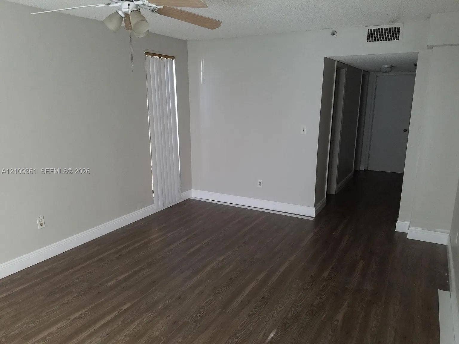 Wood-finish flooring, neutral wall tones, and ceiling fan with integrated lighting