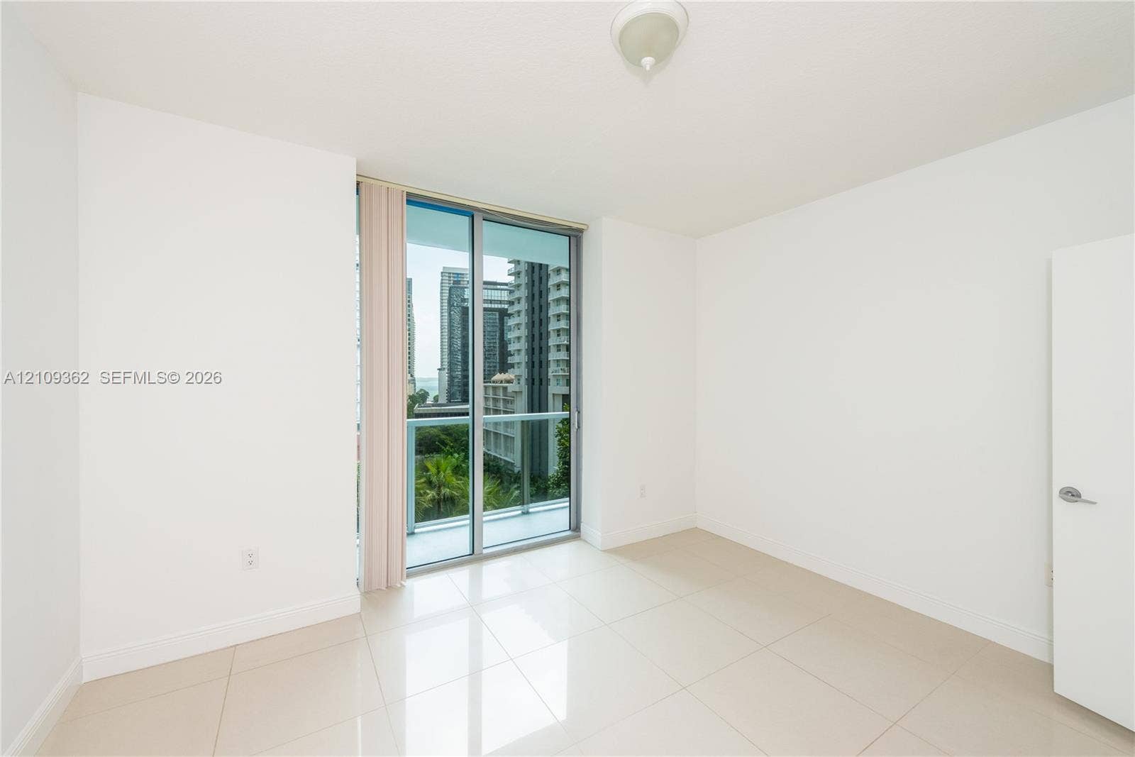 79 SW 12th Street, #1107-S, Miami, FL 33130 Neutral interior space featuring polished tile flooring, glass sliding balcony doors, and a ceiling-mounted light fixture