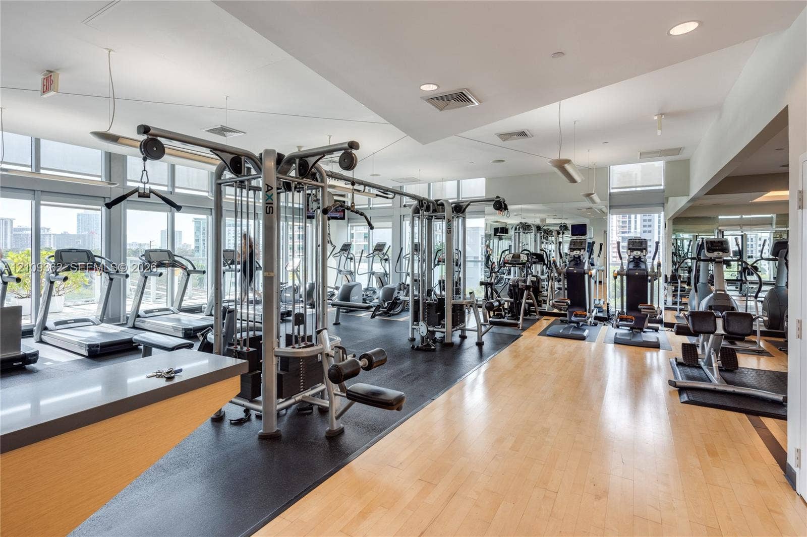 79 SW 12th Street, #1107-S, Miami, FL 33130 Fitness center featuring floor-to-ceiling windows, light-toned wood-finish flooring, rubberized workout surfacing, recessed lighting, and mirrored walls