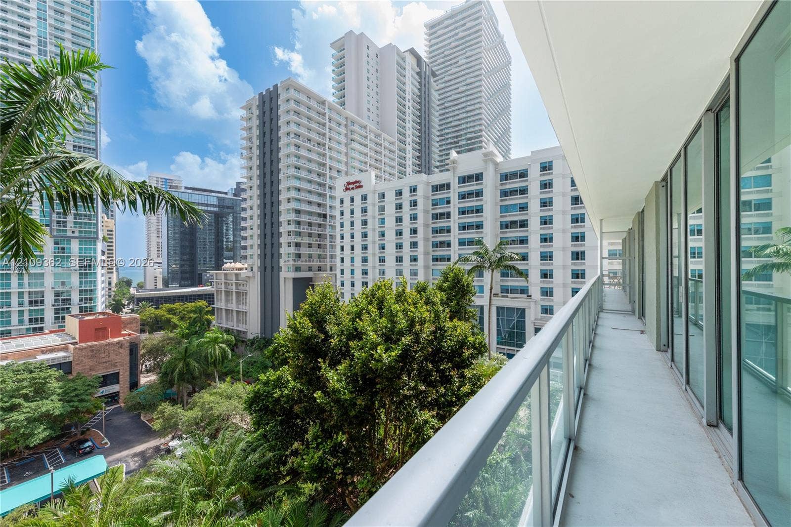 79 SW 12th Street, #1107-S, Miami, FL 33130 Covered balcony featuring glass paneled railings, floor-to-ceiling windows, and concrete flooring