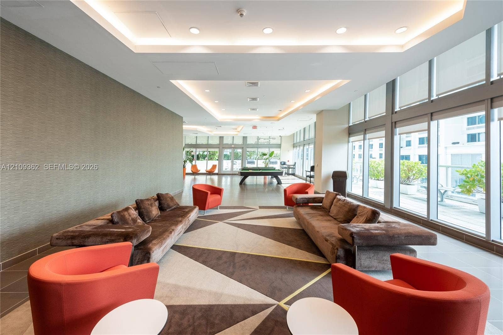 79 SW 12th Street, #1107-S, Miami, FL 33130 Common area featuring recessed tray ceilings with integrated lighting, floor-to-ceiling windows, and textured wall finish