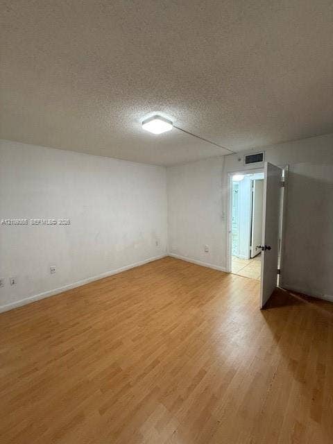 Room featuring wood-finish flooring and a central flush-mount ceiling light
