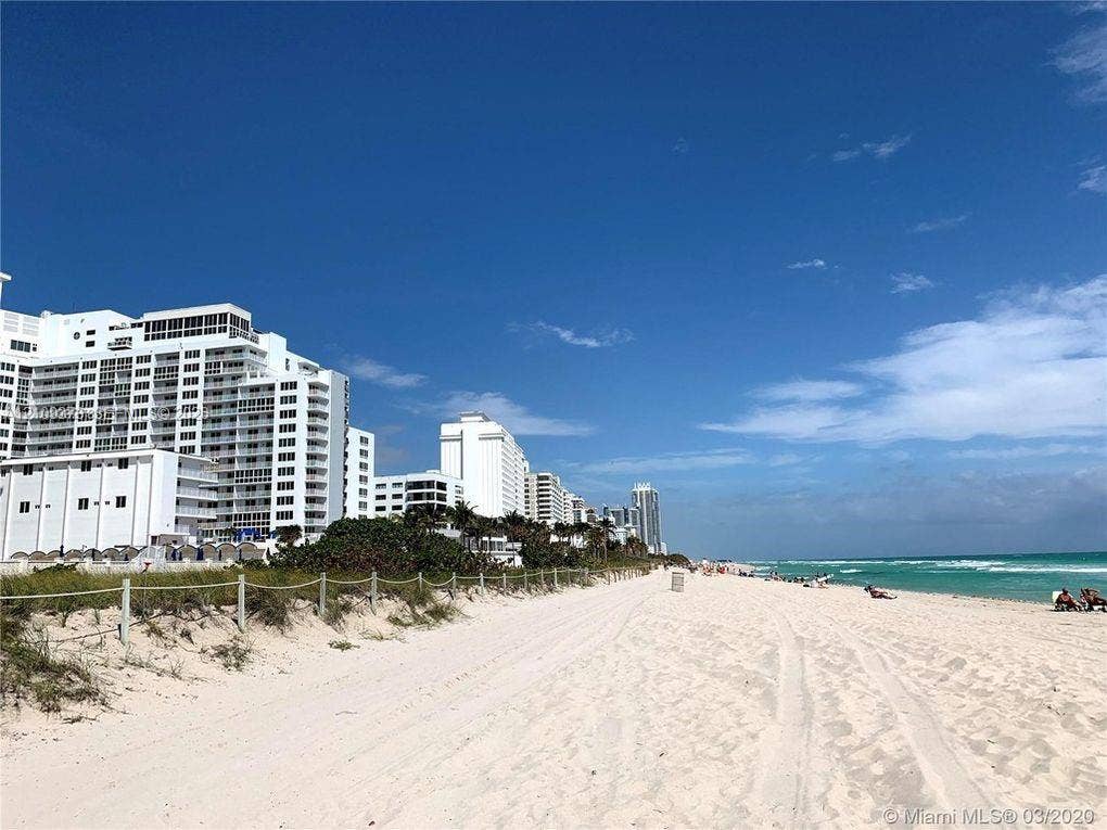Direct beach access with sandy shoreline, coastal dunes, and proximity to oceanfront high-rise structures