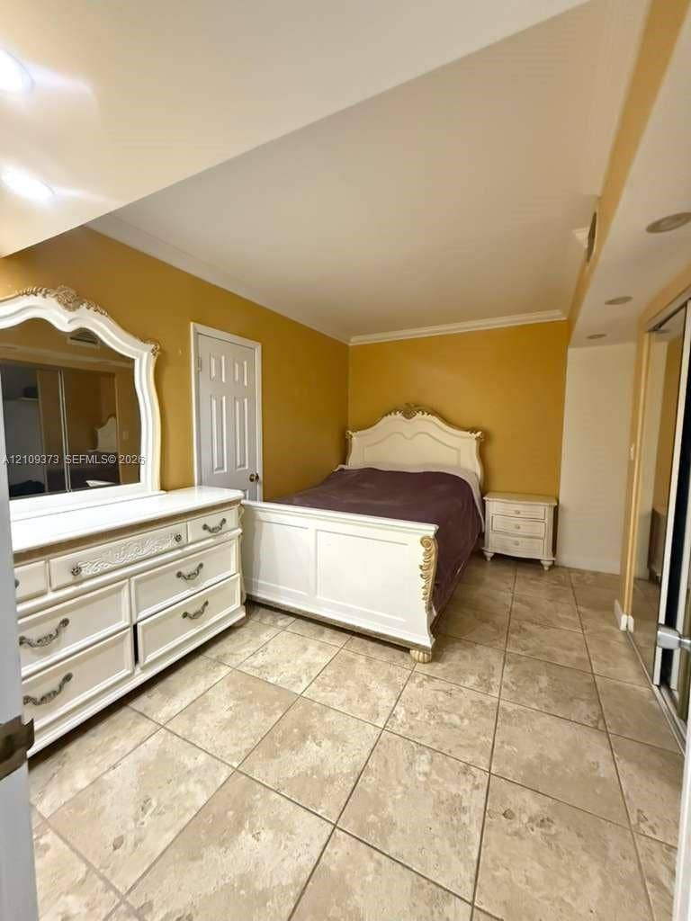 Room featuring large-format stone-finish floor tiles, recessed ceiling lighting, and mirrored closet doors