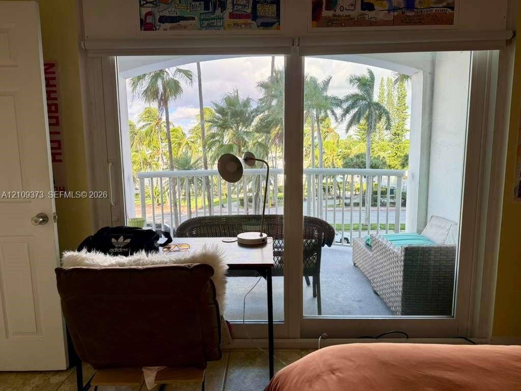 Large floor-to-ceiling sliding glass doors opening to a covered private balcony with vertical white railing