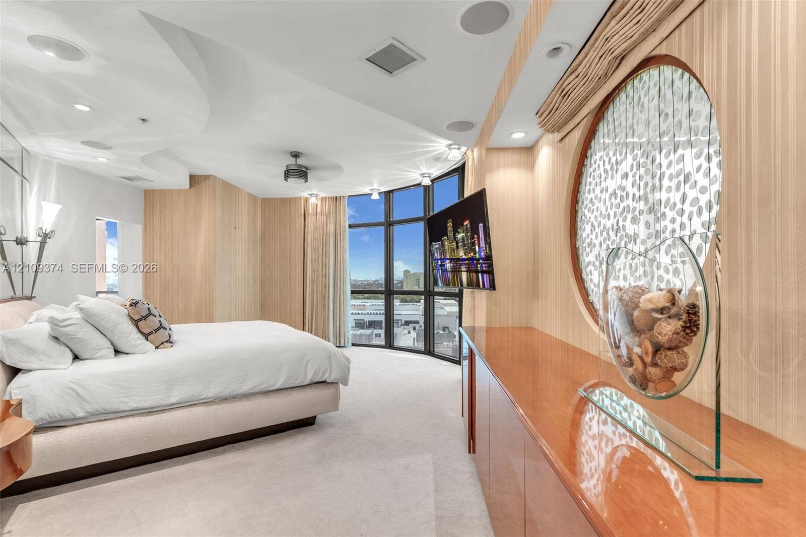 100 N Federal Highway, #1, Fort Lauderdale, FL 33301 Floor-to-ceiling windows with panoramic exterior exposure, curved architectural ceiling detail, built-in cabinetry with high-gloss finish, circular wall accent, and integrated audio speakers