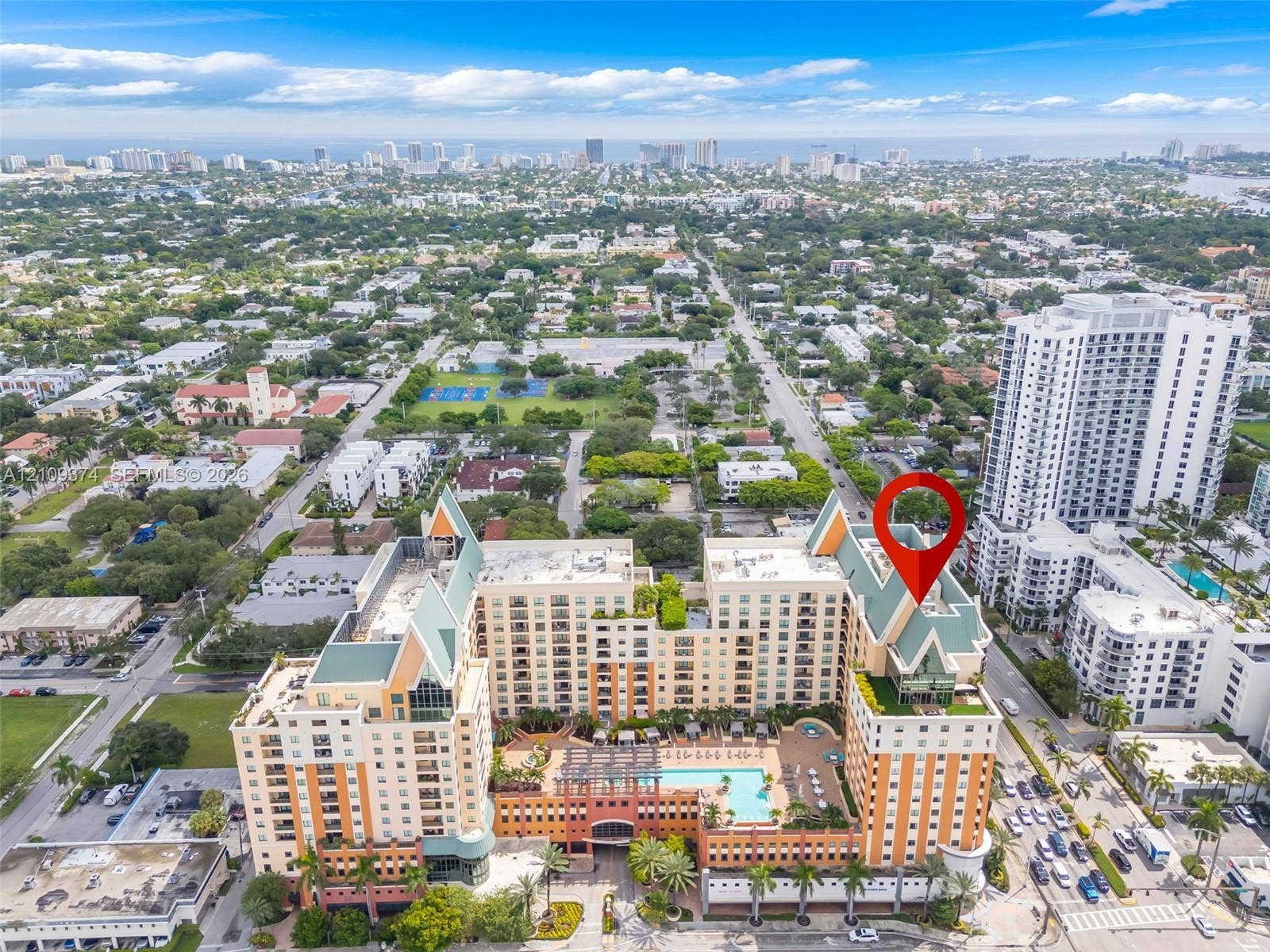100 N Federal Highway, #1, Fort Lauderdale, FL 33301 High-rise residential complex featuring a central courtyard swimming pool, multiple stepped balconies, steep pitched rooflines, and a structured exterior design