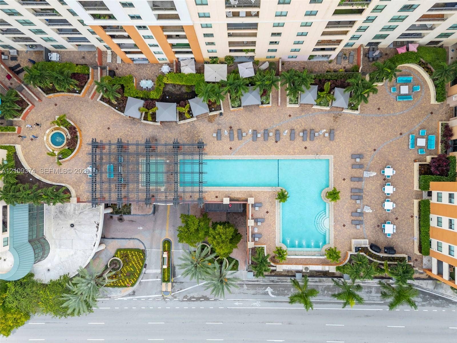 100 N Federal Highway, #1, Fort Lauderdale, FL 33301 Aerial perspective of a multi-level complex featuring an L-shaped swimming pool, paved sundeck, decorative pergola, manicured landscaping, and a circular fountain