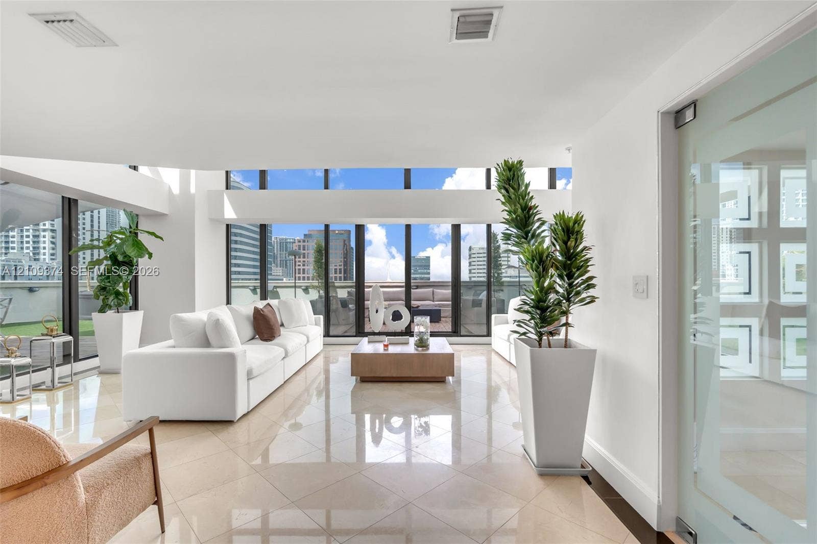 100 N Federal Highway, #1, Fort Lauderdale, FL 33301 Expansive living area featuring floor-to-ceiling windows, polished stone flooring, and a glass-panel door