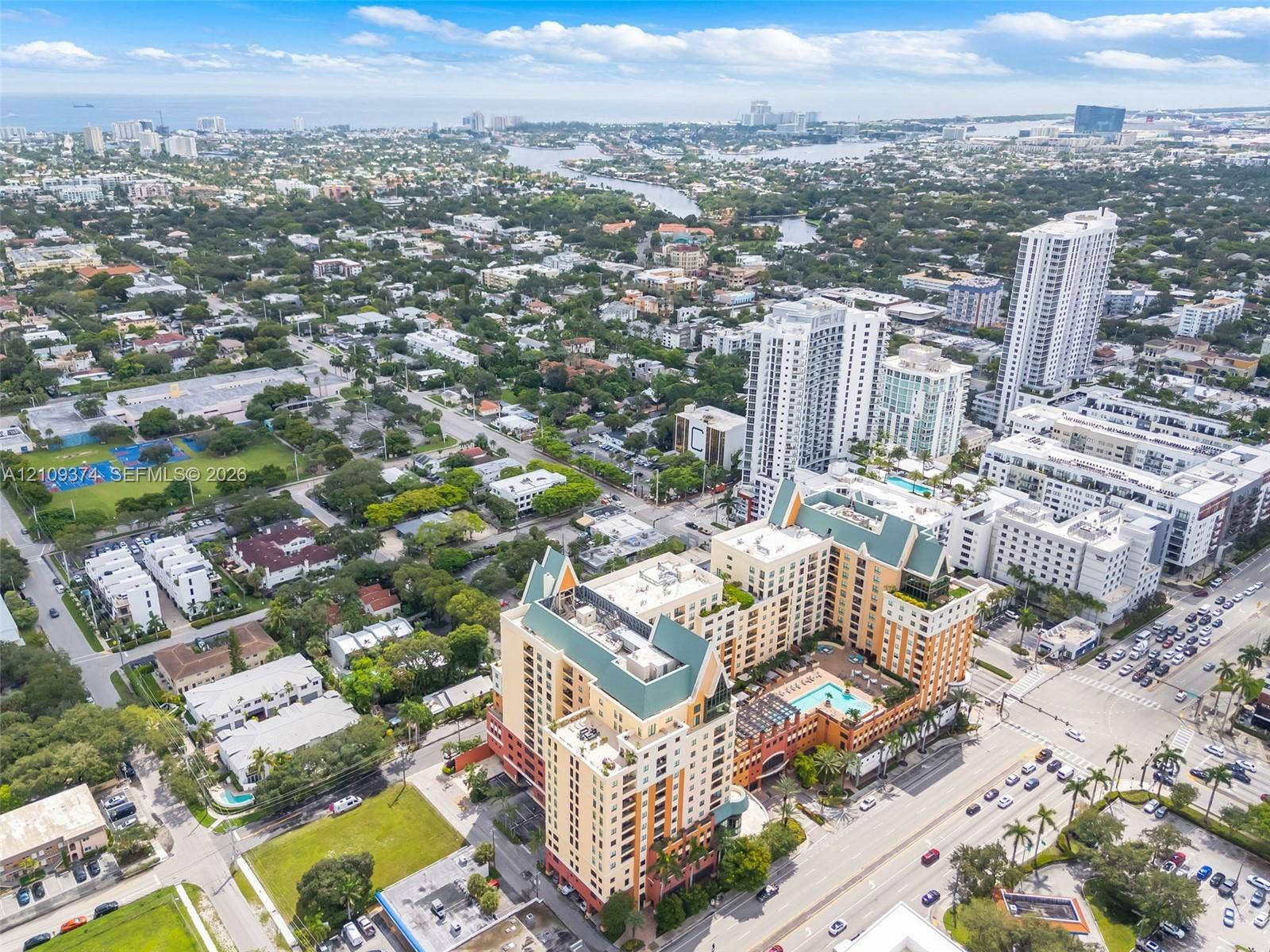 100 N Federal Highway, #1, Fort Lauderdale, FL 33301 High-rise residential complex featuring a podium-level swimming pool, terra cotta facade, pitched green roofing, and ground-level retail space