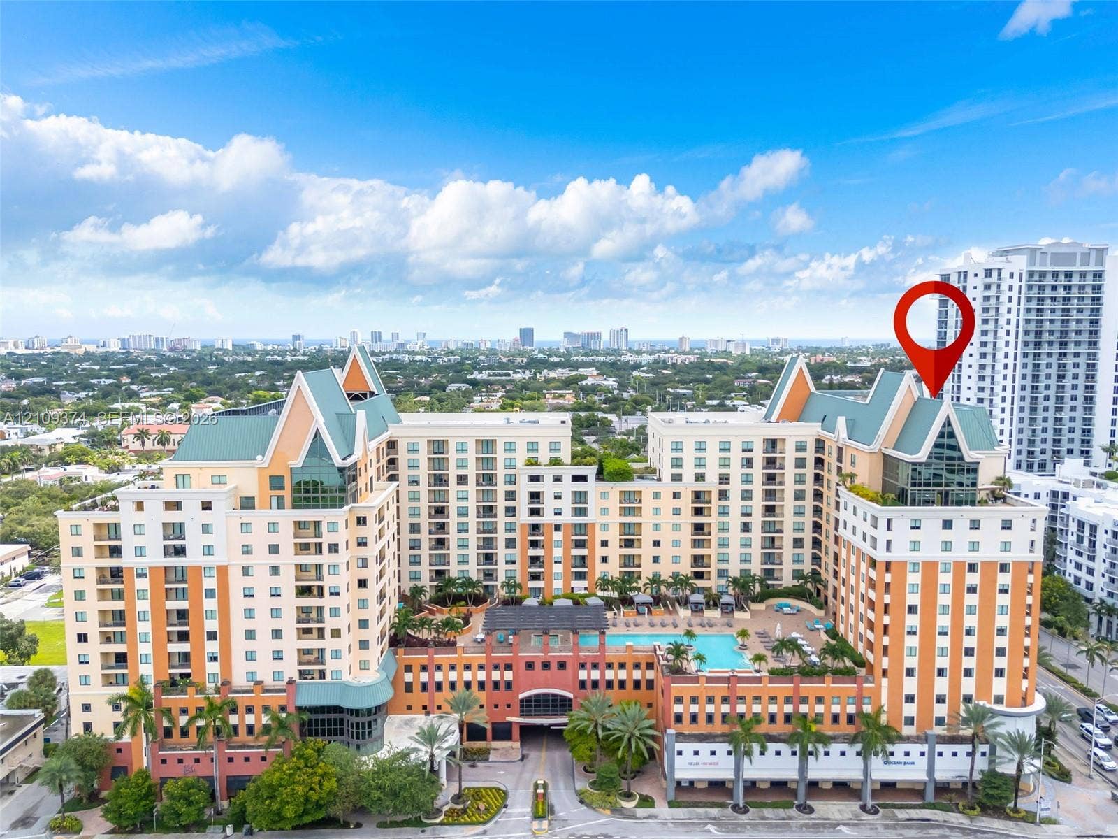 100 N Federal Highway, #1, Fort Lauderdale, FL 33301 Multi-story residential complex featuring steep-pitched roof gables, stucco facade, integrated swimming pool, and lush perimeter landscaping
