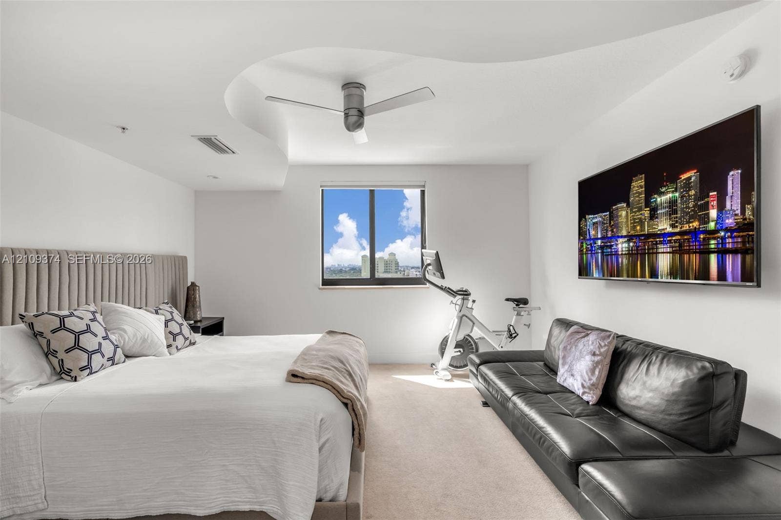 100 N Federal Highway, #1, Fort Lauderdale, FL 33301 Custom tray ceiling featuring a curved architectural design, ceiling-mounted brushed-finish fan, wall-to-wall carpeting, and single-pane window