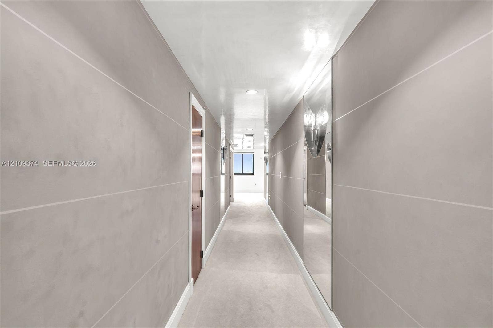 100 N Federal Highway, #1, Fort Lauderdale, FL 33301 Hallway featuring matte grey paneling with horizontal reveals, inset floor-to-ceiling mirrored walls, and recessed ceiling lighting