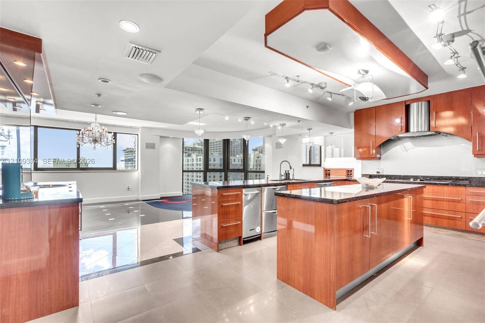 100 N Federal Highway, #1, Fort Lauderdale, FL 33301 Kitchen featuring wood-finish cabinetry, stone-surface countertops, stainless steel appliances, tiered tray ceiling, and tile flooring