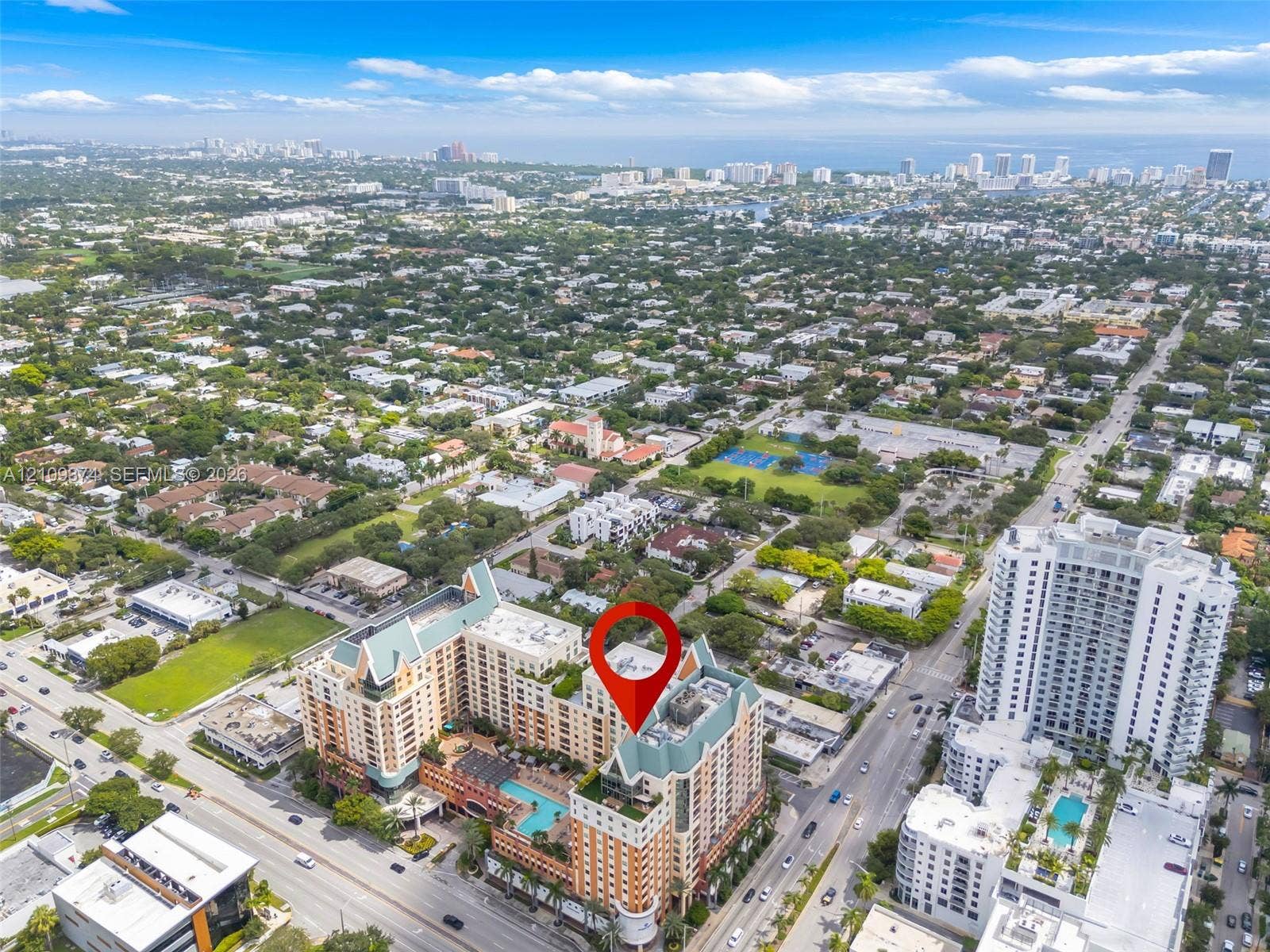 100 N Federal Highway, #1, Fort Lauderdale, FL 33301 Aerial perspective of a multi-story residential building featuring a sprawling outdoor pool deck, terraced balconies, and a distinctive peaked roofline