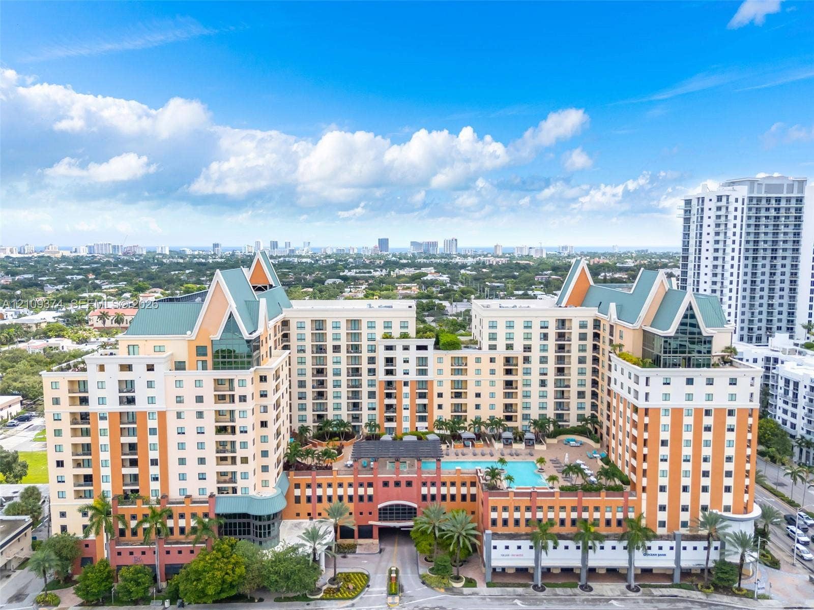 100 N Federal Highway, #1, Fort Lauderdale, FL 33301 Multi-story high-rise building featuring a structured facade, gabled rooflines, recessed balconies, an elevated outdoor swimming pool, and manicured tropical landscaping