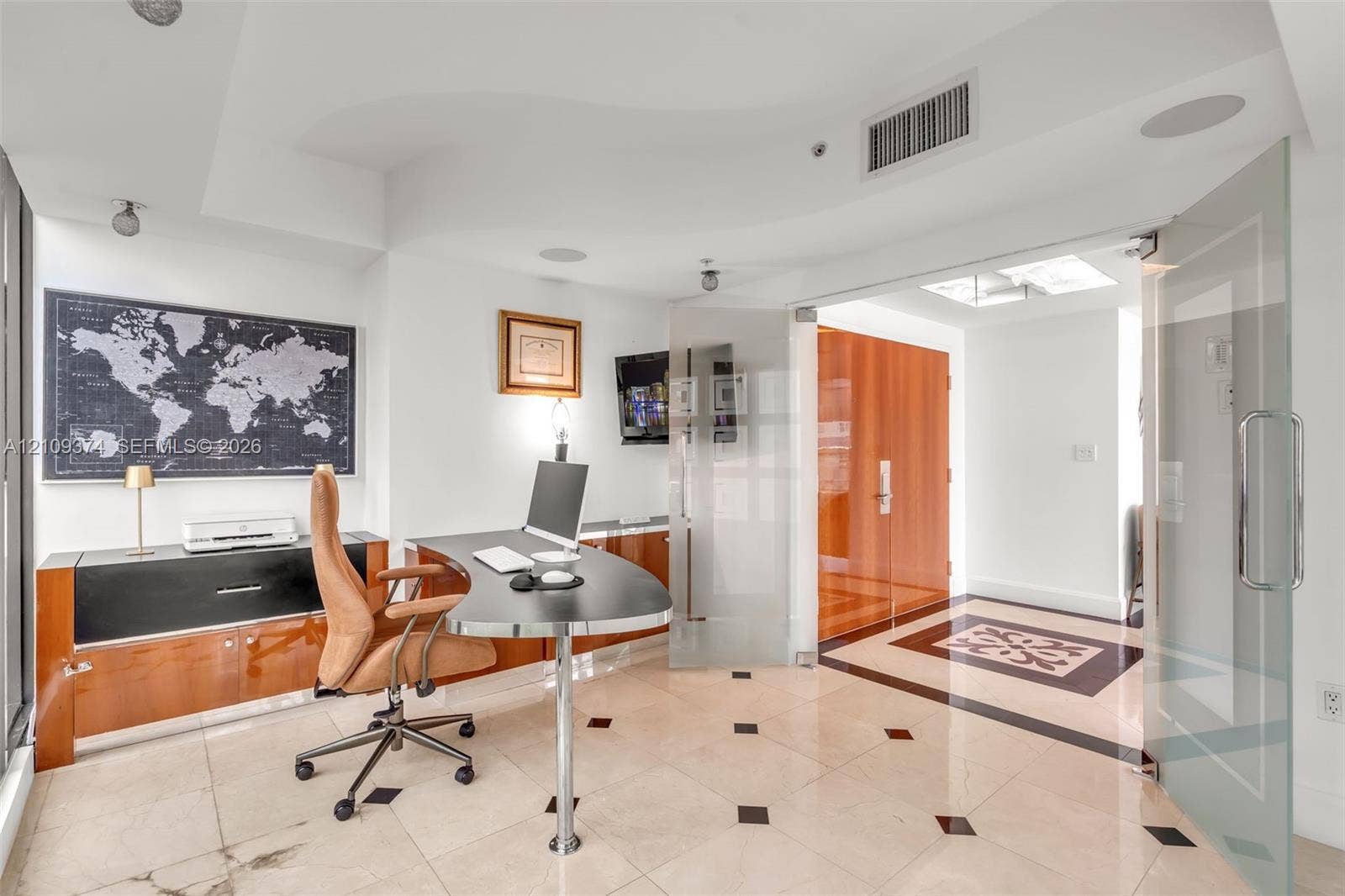 100 N Federal Highway, #1, Fort Lauderdale, FL 33301 Light-filled room featuring large-format stone flooring with decorative inlay, custom wood-finish built-in cabinetry, frosted glass pivot entry doors, and recessed ceiling lighting