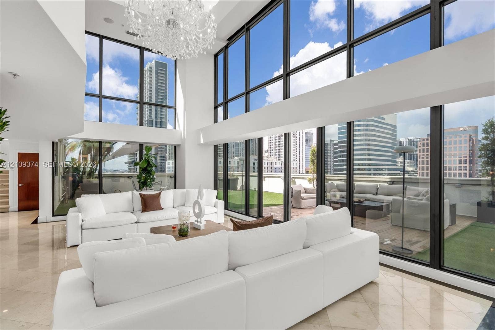 100 N Federal Highway, #1, Fort Lauderdale, FL 33301 Double-height ceiling, floor-to-ceiling windows, polished stone flooring, custom crystal chandelier, and integrated exterior terrace
