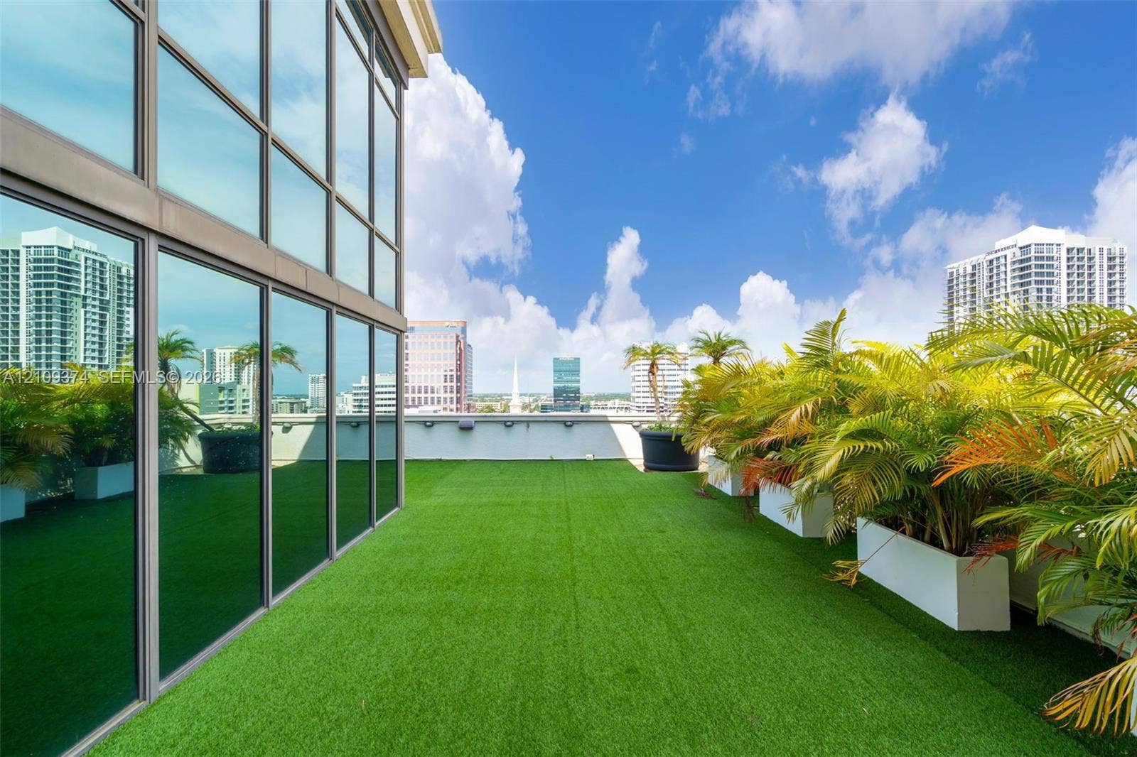 100 N Federal Highway, #1, Fort Lauderdale, FL 33301 Expansive outdoor terrace featuring synthetic turf flooring, floor-to-ceiling glass paneling, and built-in rectangular planters