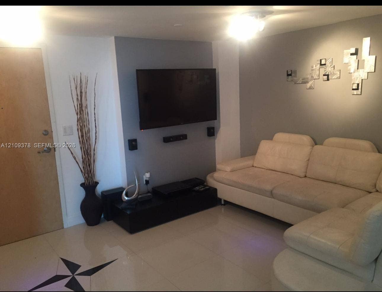 350 S Miami Avenue, #2207, Miami, Miami, FL 33130 Interior space featuring large-format tile flooring, a recessed accent wall with integrated wall-mounted television, and flush-mount ceiling lighting