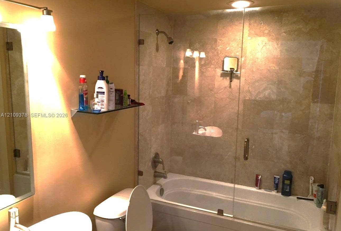 350 S Miami Avenue, #2207, Miami, Miami, FL 33130 Full-height tile shower surround with a frameless glass panel, built-in glass shelving, vanity mirror with wall-mounted lighting, and a recessed shower fixture
