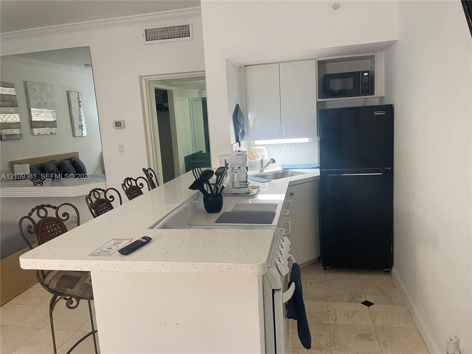 26 Diplomat Parkway, #2351, Hallandale Beach, FL 33009 Neutral-tone floor tiles and built-in wet bar featuring a peninsula counter
